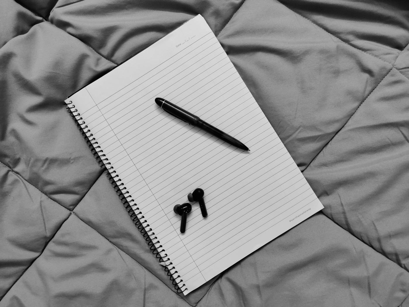 A Pen and a Notebook on the Bed