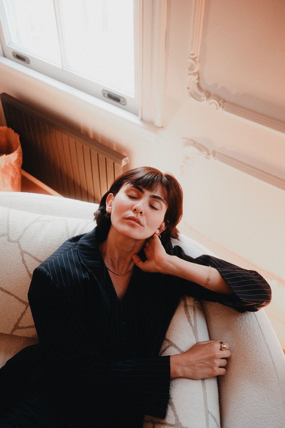 Woman Relaxing on Sofa in Sunlit Room