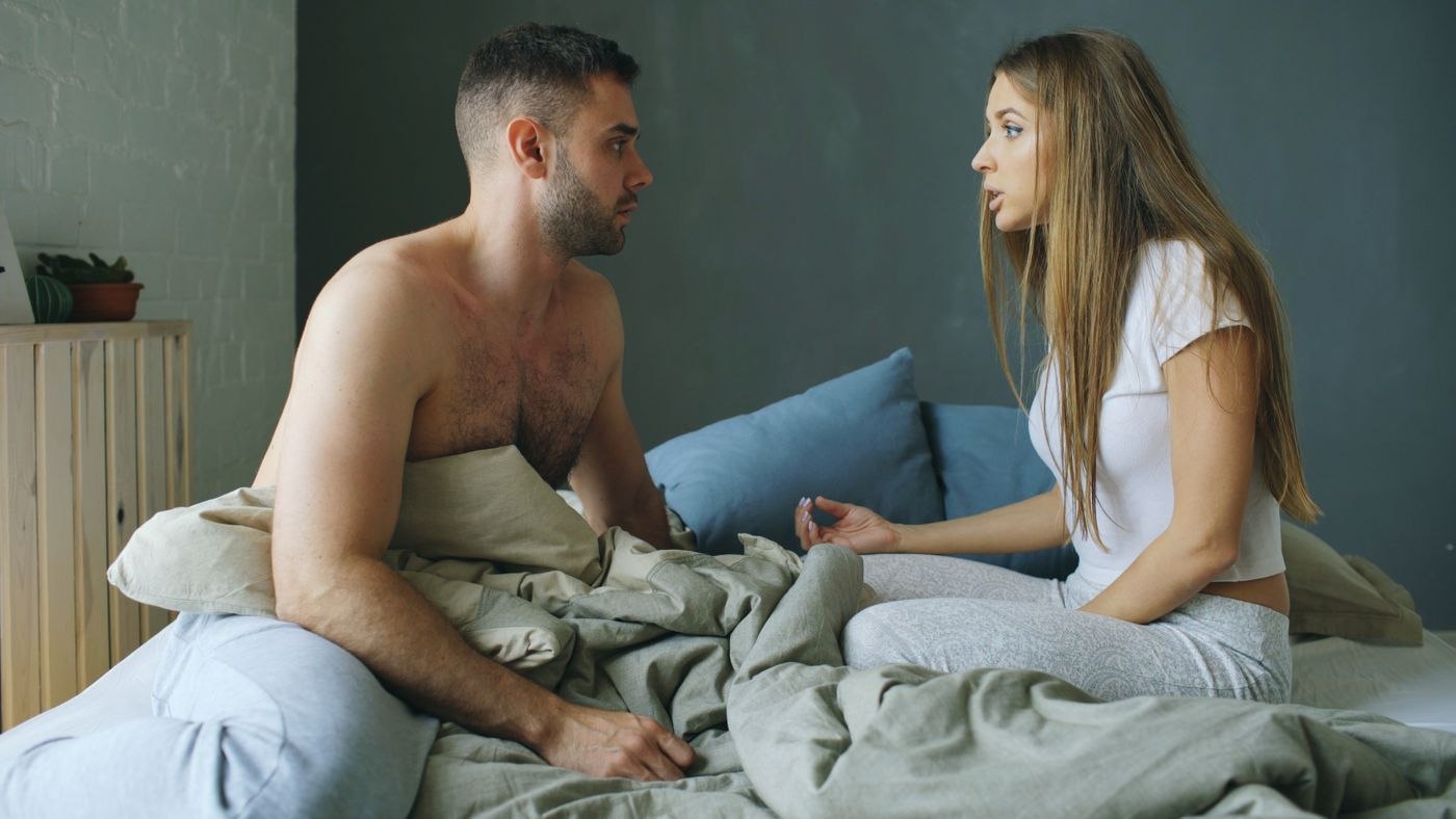 Couple in Bed Having a Serious Conversation